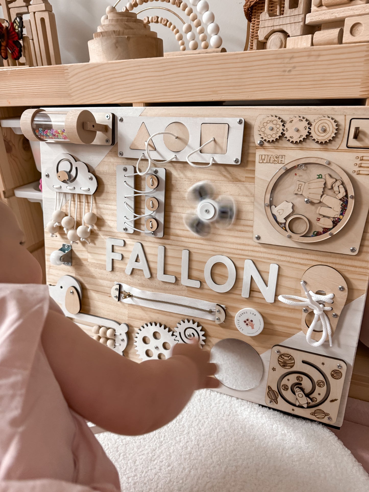 baby playing with toddler busy board