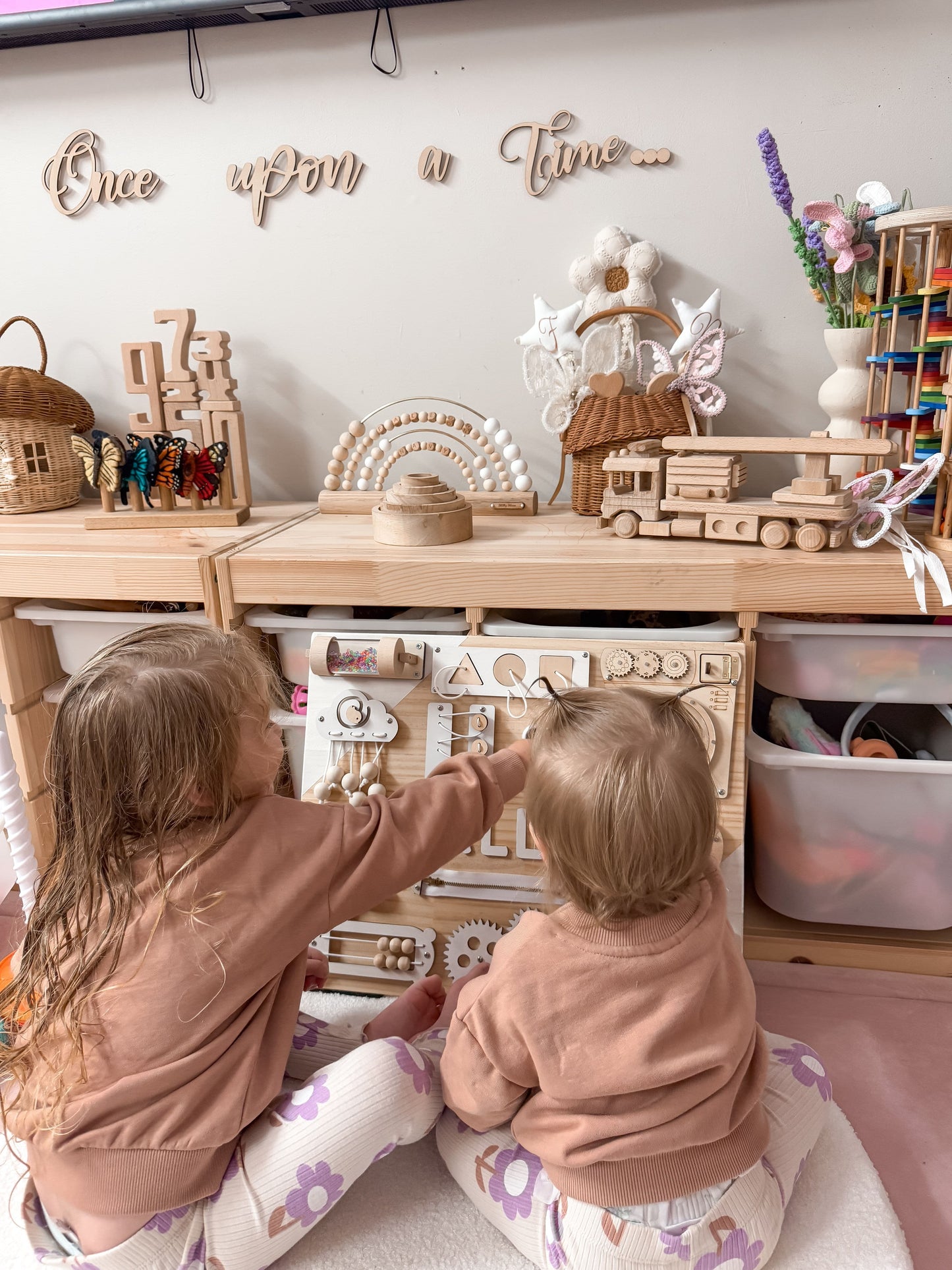 Toddlers playing with busy board